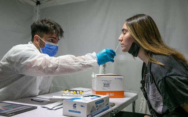 A medical employee takes a COVID-19 rapid antigen sample in Lod on October 17, 2021. (Yossi Aloni/Flash90)