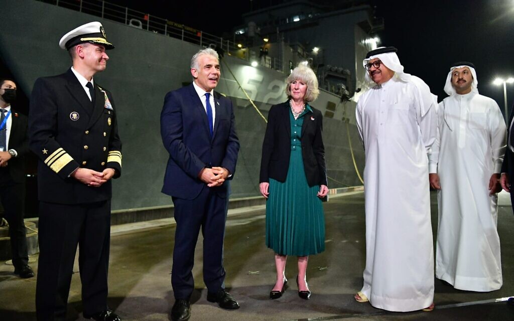 From left, US Fifth Fleet commander Vice Admiral Brad Cooper, Foreign Minister Yair Lapid, US charge d'affaires in Bahrain Maggie Nardi, and Bahrain's FM Abdullatif al Zayani in front of the USS Pearl Harbor in Manama, September 20 2021 (Shlomi Amsalem GPO)
