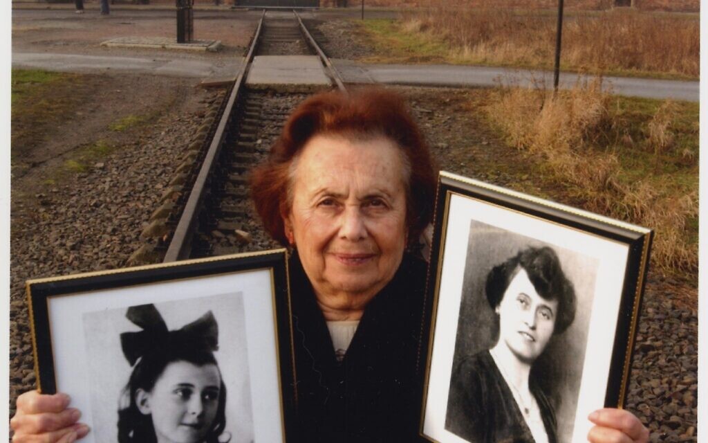 Lily Ebert holds photos of her sisters on a visit to Auschwitz. (Courtesy)