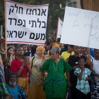 Members of the Hebrew Israelites Community of the southern city of Dimona protest against deportation orders given to some of their members, Habima Square, Tel Aviv, June 1, 2021. Th banner says, 'We are an integral part of the People of Israel.'  (Miriam Alster/Flash90)