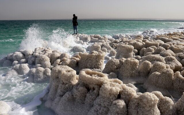 A hiker visits patterns formed by crystalized minerals in Kibbutz Ein Gedi area at the shore of the southern part of the Dead Sea, a dried-up sea stretch which exposed and created a salt plain, on December 26, 2020. (Menahem KAHANA / AFP)
