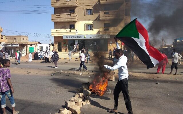 Sudanese opponents of the military coup gather behind a roadblock as they take part in a protest in the capital Khartoum's twin city of Umdurman, on November 13, 2021. (AFP)