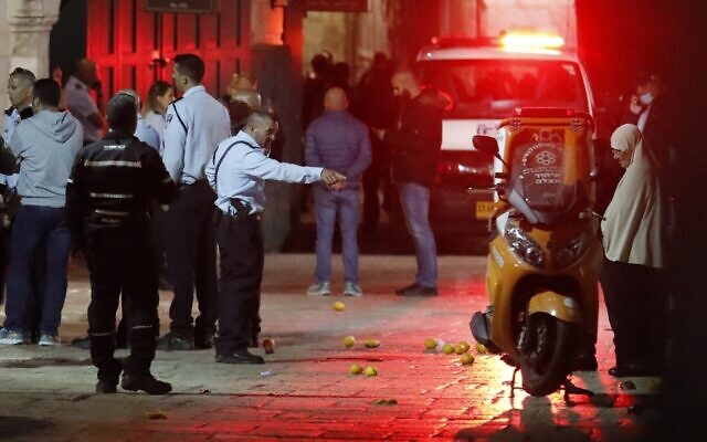 An ambulance drives through as Israeli police gather at the scene of an alleged stabbing attack in Jerusalem's Old City on November 17, 2021. (Ahmad Gharabli/AFP)