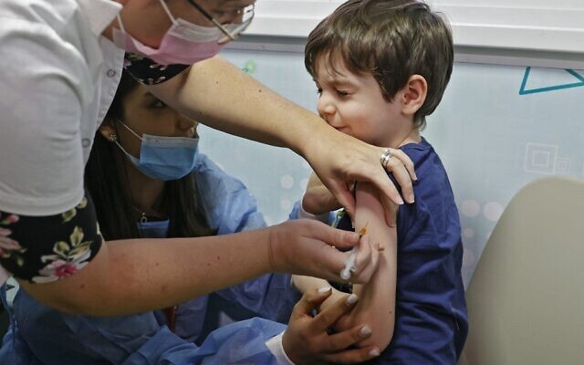 Israeli boy Itamar, 5, receives a dose of the Pfizer/BioNTech Covid-19 vaccine at the Meuhedet Healthcare Services Organization in Tel Aviv, on November 22, 2021, as Israel begins its coronavirus vaccination campaign for 5 to 11-year-olds. (Jack Guez/AFP)