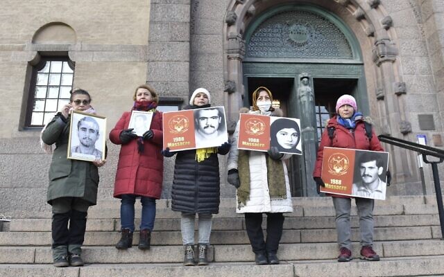 People demonstrate outside the Stockholm District Court in connection with the war crime trial against Hamid Noury who is being questioned in Stockholm District Court, Stockholm, November 23, 2021 (Duygu GETIREN / TT NEWS AGENCY / AFP)