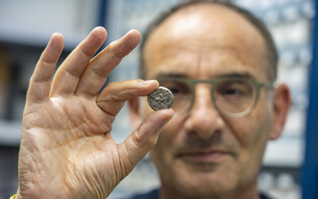 Dr. Robert Kool holds the rare silver coin (Yaniv Berman/City of David and the Israel Antiquities Authority)