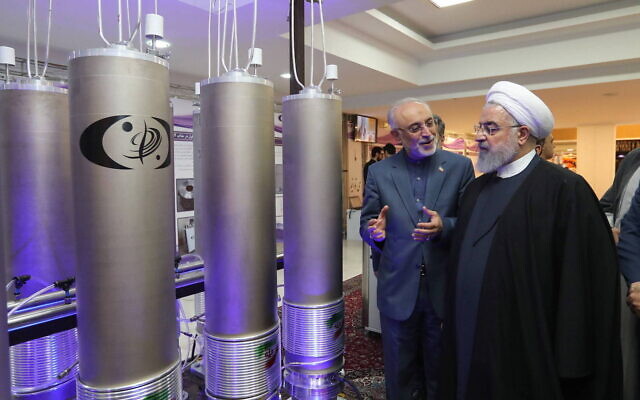 Iran's President Hassan Rouhani, right, is shown new centrifuges and listens to head of the Atomic Energy Organization of Iran Ali Akbar Salehi, while visiting an exhibition of Iran's new nuclear achievements in Tehran, Iran, April 10, 2021. (Iranian Presidency Office via AFP)