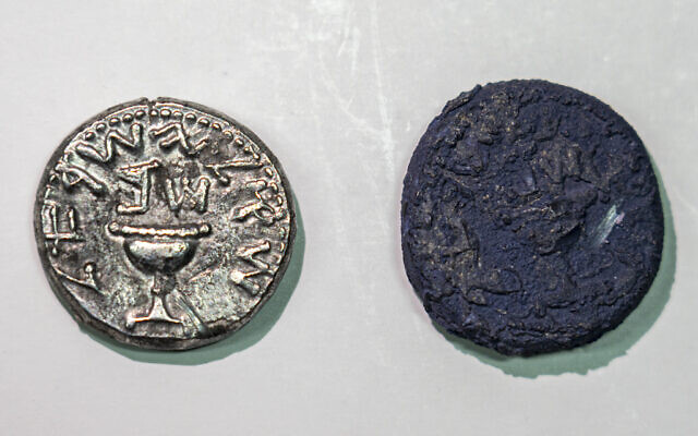 The silver coin next to a charred coin that was burned in the destruction of Jerusalem (Yaniv Berman/City of David and the Israel Antiquities Authority)