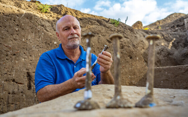 Excavation director Daniel Varga with the glass vials discovered. (Yaniv Berman/Israel Antiquities Authority)