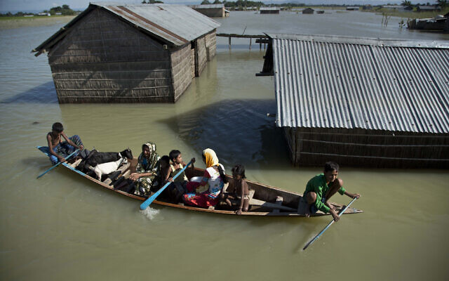 In this July 31, 2016, file photo, a flood-affected family with their goats travel on a boat in the Morigaon district, east of Gauhati, northeastern Assam state, India. (AP Photo/Anupam Nath, File)