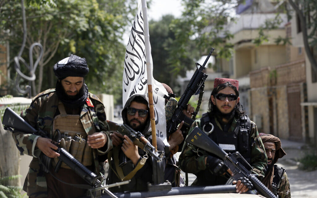 In this August 19, 2021, photo, Taliban fighters display their flag on patrol in Kabul, Afghanistan (AP Photo/Rahmat Gul, File)