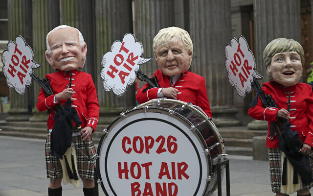 Oxfam 'Big Head' caricatures of world leaders Joe Biden, Boris Johnson and Angela Merkel, protest on the fringes of the COP26 UN Climate Summit in Glasgow, Scotland, November 1, 2021. (AP Photo/Scott Heppell)