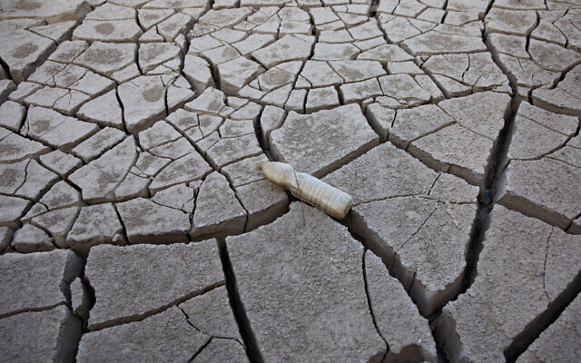 An empty plastic bottle is seen in a crack of mud at the Shlomo River, near Eilat, Israel, November 3, 2021. (AP Photo/Oded Balilty)