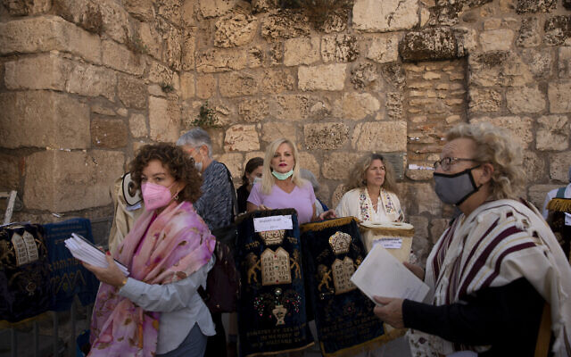 Members of the Women of the Wall display the Torah scroll covers as they gather for the Rosh Hodesh, or new month prayer in the women's section at the Western Wall, the holiest site where Jews can pray, in the Old City of Jerusalem, Friday, Nov. 5, 2021. (AP Photo/Maya Alleruzzo)