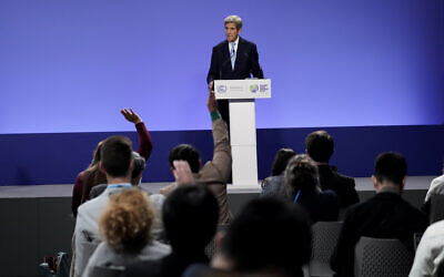 Audience members raise their hands to ask questions as John Kerry, United States Special Presidential Envoy for Climate speaks immediately after a press conference given by China's Special Envoy for Climate Change Xie Zhenhua at the COP26 UN Climate Summit, in Glasgow, Scotland, November 10, 2021. (AP Photo/Alberto Pezzali)