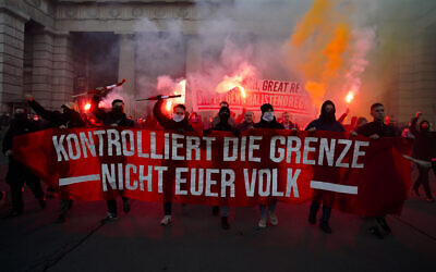 Demonstrators shout slogans and light flares during a demonstration against measures to battle the coronavirus pandemic in Vienna, Austria, Saturday, Nov. 20, 2021. (AP Photo/Florian Schroetter)