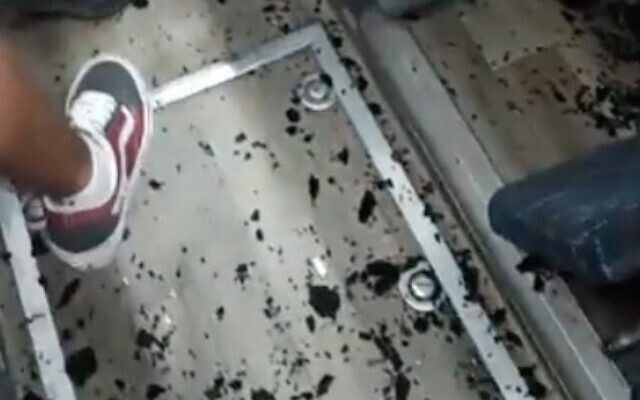Screen capture from video of smashed glass on the floor of a bus that was stoned as it traveled from Tel Aviv to Eilat, November 30, 2021. (Twitter)