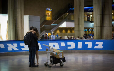 A couple reunites in the arrival hall of Ben Gurion Airport. (Miriam Alster/FLASH90)