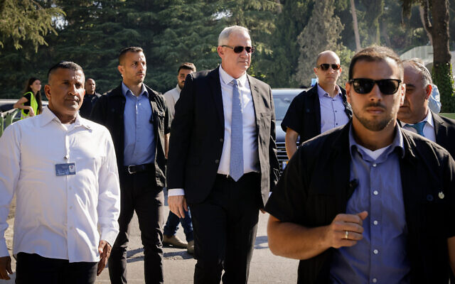 Defense Benny Gantz, escorted by security guards, at Mount Herzl national cemetery in Jerusalem, on June 20, 2021. (Olivier Fitoussi/Flash90)