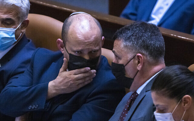 Prime Minister Naftali Bennett (left) speaks with Justice Minister Gideon Sa'ar in the Knesset, on June 28, 2021. (Olivier Fitoussi/Flash90)