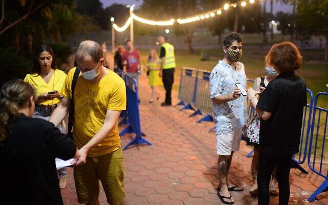 Israelis present their Green Pass certificates at the entrance to a concert venue in Tel Aviv on August 7, 2021. (Tomer Neuberg/Flash90)