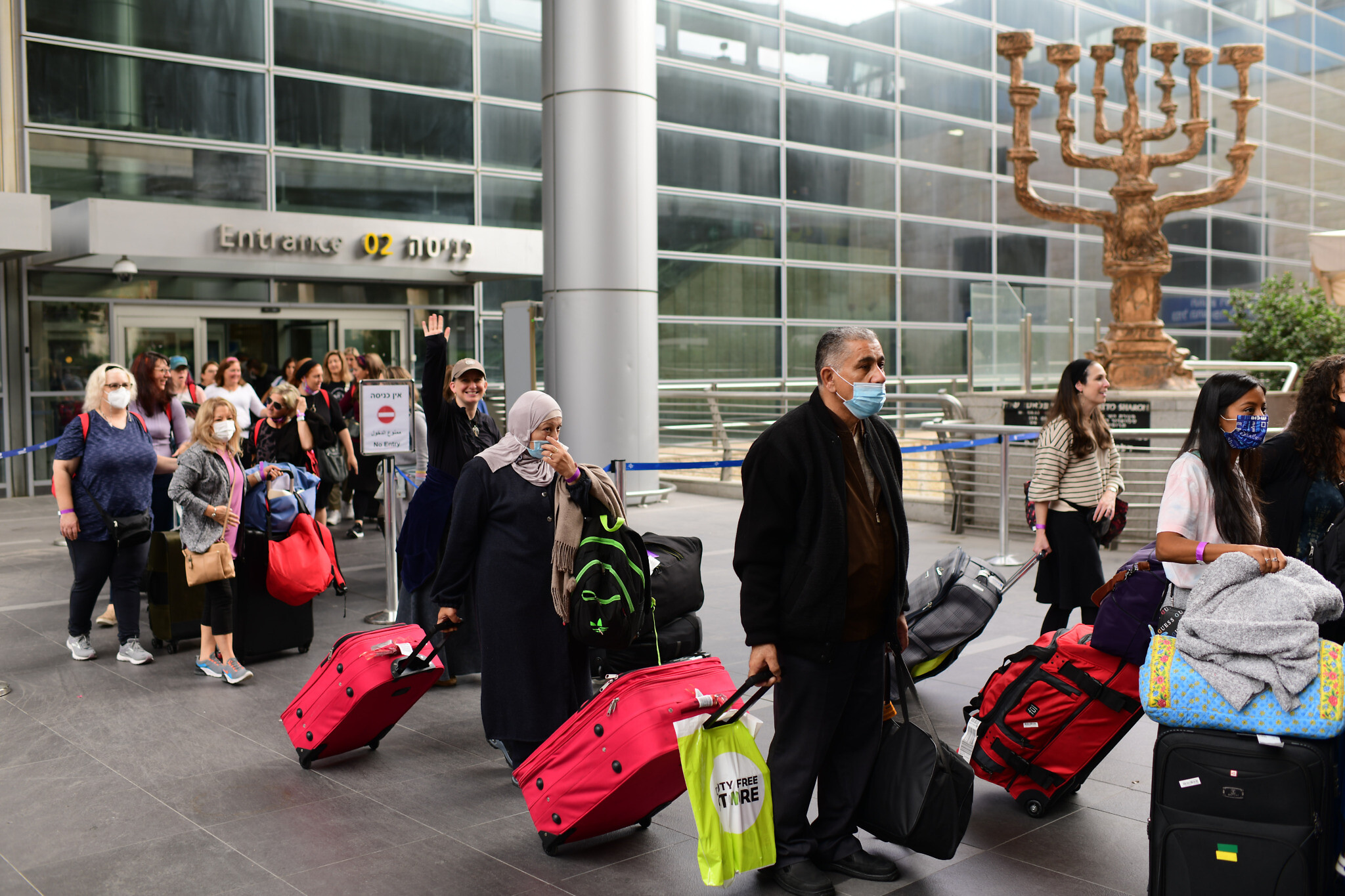 Travelers seen exiting Ben Gurion International Airport, as Israel opens its borders and allows tourists to enter the country after months of being shut due to the COVID-19 pandemic, November 1, 2021. (Tomer Neuberg/FLASH90