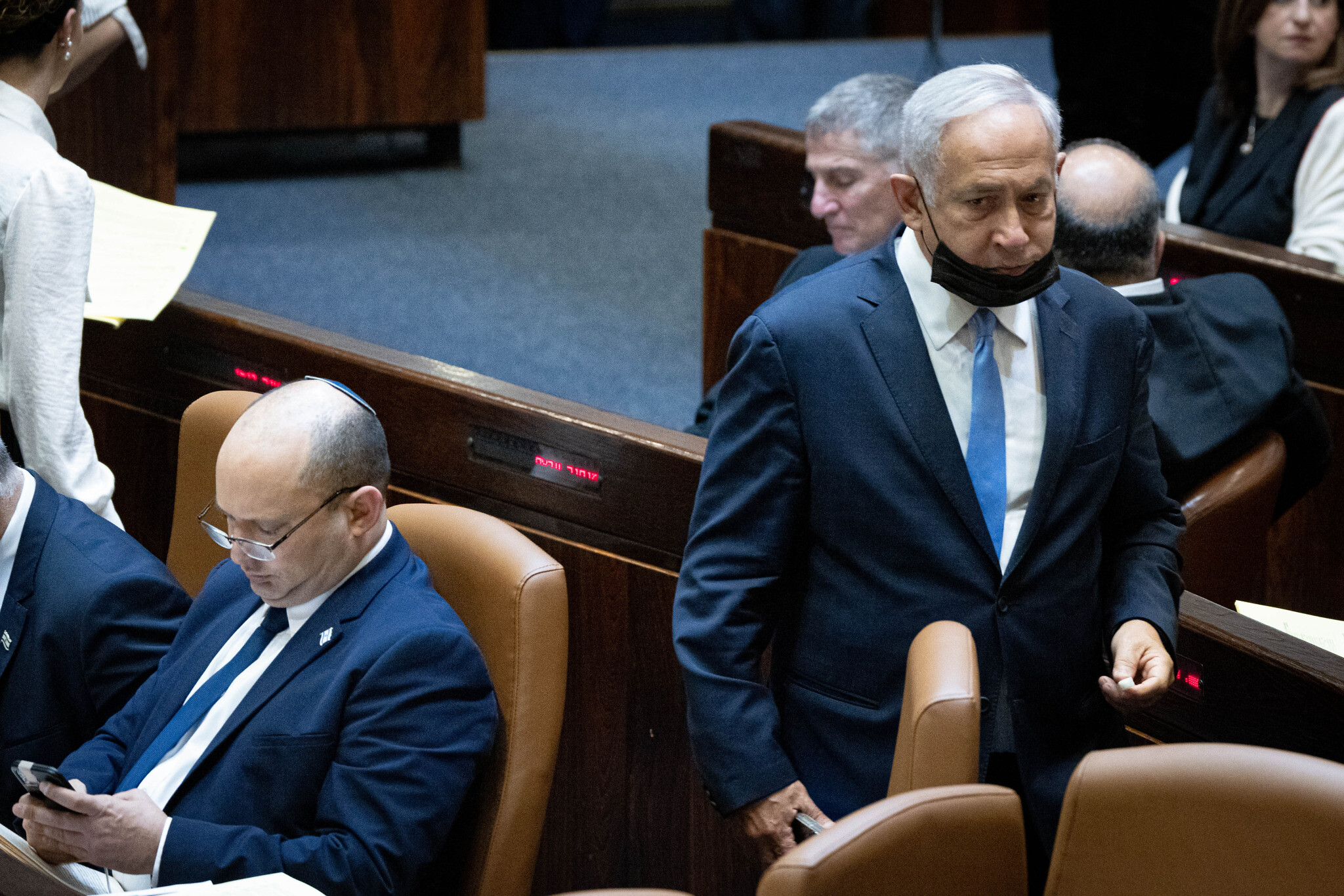 Opposition Leader Benjamin Netanyahu (R) walks past Prime Minister Naftali Bennett during voting on the state budget, November 4, 2021. (Yonatan Sindel/Flash90)