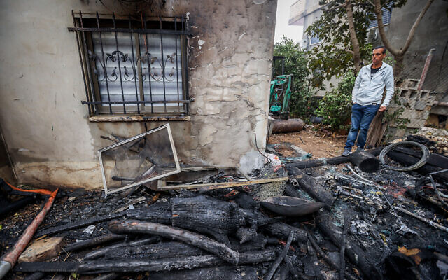 A man inspects the damage after a fire in Ma'alot-Tarshiha, northern Israel, on November 14, 2021 (David Cohen/Flash90)