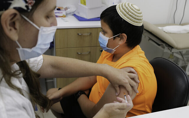 An Israeli child receives a COVID-19 vaccine at a Maccabi vaccination center in Katzrin on November 24, 2021. (Michael Giladi/Flash90)
