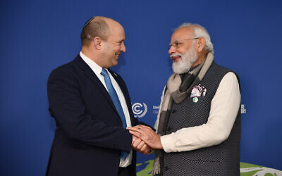 Prime Minister Naftali Bennett (left) speaks with Indian Prime Minister Narendra Modi at the COP26 climate conference in Glasgow, Scotland, on November 2, 2021. (Haim Zach/GPO)