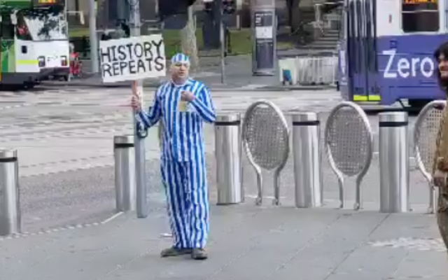 Screen capture from video of a man dressed in a outfit reminiscent of a Holocaust concentration camp inmate as he protests against COVID-19 vaccinations and health laws in Melbourne Australia, October 30, 2021. (Anti-Defamation Commission)