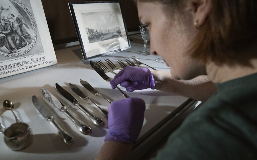 Senior conservator Jenna Taylor installs a fish knife belonging to Mr. and Mrs. Schindler in the Holocaust Gallery at London's Imperial War Museum, September 30, 2021. (Courtesy of the IWM)