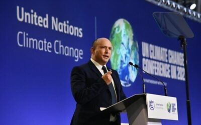 Prime Minister Naftali Bennett delivers a speech on stage during a meeting at the COP26 UN Climate Change Conference in Glasgow, Scotland, on November 1, 2021. (Haim Zach/GPO)