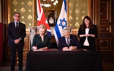 Foreign Minister Yair Lapid (R) signs an MOU with UK Foreign Secretary Liz Truss at the Foreign Office, in London, November 29, 2021. (Stuart Mitchell/ GPO)