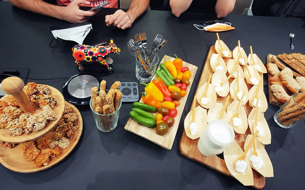 Remilk's cow-free cream cheese served alogside vegetables and baked goods at the company's offices in Rehovot, November 2021. (Times of Israel staff)