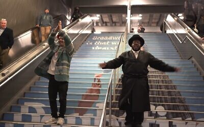 Screenshot from vidoa of Kosha Dillz, left, and Nissim Black performing across Midtown Manhattan in the video to 'The Hanukkah Song 2.0.' (JTA)
