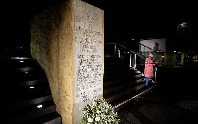 A woman passes a memorial stone where the former Synagogue was standing before it was destroyed by the Nazis in 1938 in Dortmund, Germany,, Nov. 9, 2021. (AP Photo/Martin Meissner)