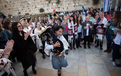 Women of the Wall dance with a Torah Scroll during a Rosh Hodesh service in the Western Wall plaza in 2015 (Miriam Alster / Flash90)