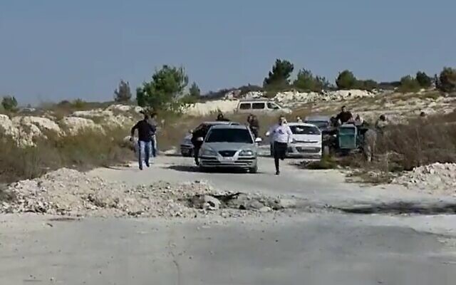 Settlers chase after Palestinians near the West Bank outpost of Homesh on November 15, 2021. (Yesh Din/Screenshot)