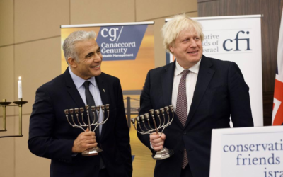 Foreign Minister Yair Lapid (L) and British Prime Minister Boris Johnson at a Conservative Friends of Israel event in London, Britain, November 29, 2021. (Stuart Mitchell)