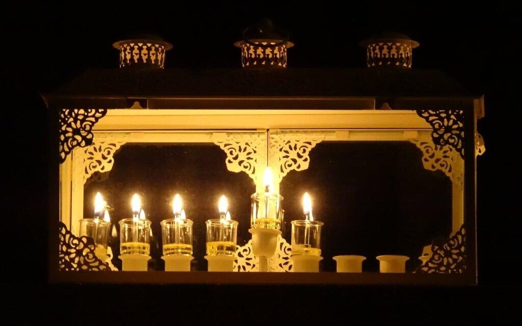 Lit Hanukkah menorahs are part of the tour in Jerusalem's Old City during the eight-day holiday, which begins November 28, 2021 (Courtesy Michal Ben Atar)