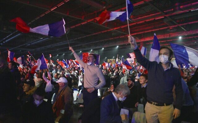 Supporters of French far-right media pundit and 2022 presidential candidate Eric Zemmour waves French national flags during a campaign rally in Villepinte, near Paris, on December 5, 2021. (Julien De Rosa/AFP)