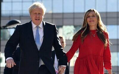 In this file photo taken on October 6, 2021 Britain's Prime Minister Boris Johnson (L) and his wife Carrie (R) arrive at the Manchester Central convention center ahead of his keynote speech on the final day of the annual Conservative Party Conference in Manchester, northwest England. (Photo by Ben STANSALL / AFP)