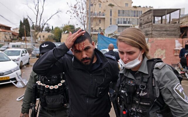 A member of the Israeli security forces reacts after being injured during an altercation with Palestinian protesters during a demonstration in the East Jerusalem neighborhood of Sheikh Jarrah, on December 17, 2021. (AHMAD GHARABLI/AFP)