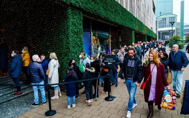 Shoppers walk in the center of Rotterdam, Netherlands, on December 18, 2021. (Marco de Swart/ANP/AFP)