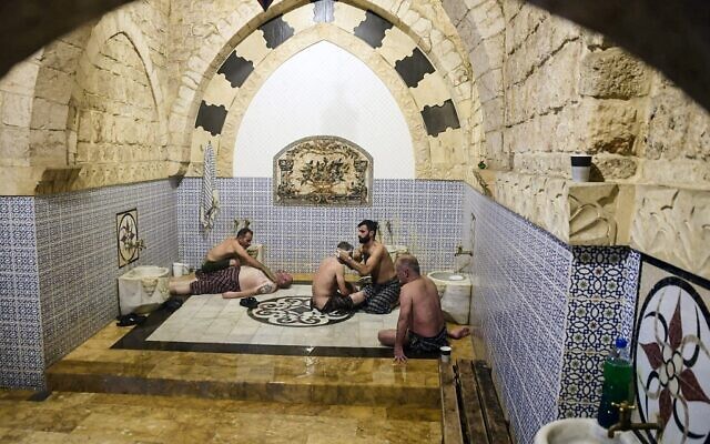 Men bathe at Hammam al-Qawas, a traditional Turkish bathhouse, in Syria's northern city of Aleppo on December 16, 2021. (Photo by AFP)