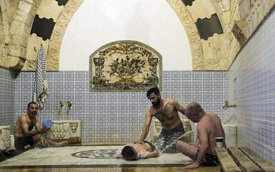 Men bathe at Hammam al-Qawas, a traditional Turkish bathhouse, in Syria's northern city of Aleppo on December 16, 2021. (Photo by AFP)