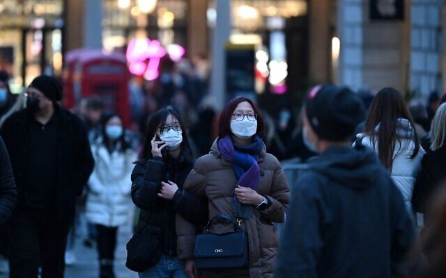 Shoppers wearing face coverings to combat the spread of COVID-19 walk through the Covent Garden area of London on December 21, 2021. (Justin Tallis/AFP)