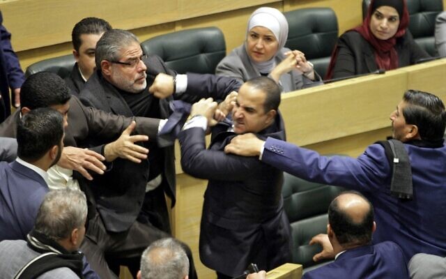 Jordanian parliament members are separated during an altercation in the parliament in the capital Amman on December 28, 2021. (Photo by AFP)