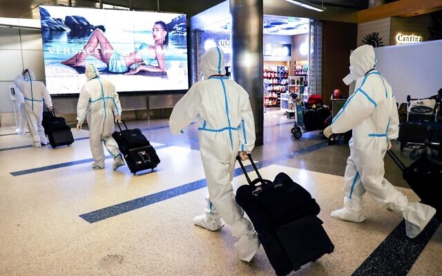 Air China flight crew members wear protective suits as they arrive in the international terminal at Los Angeles International Airport (LAX) on December 3, 2021 in Los Angeles, California. A new rapid COVID-19 testing site for international arriving passengers opened today in the Tom Bradley International Terminal after Los Angeles County confirmed its first case of the Omicron variant December 2.  (Mario Tama/Getty Images/AFP)